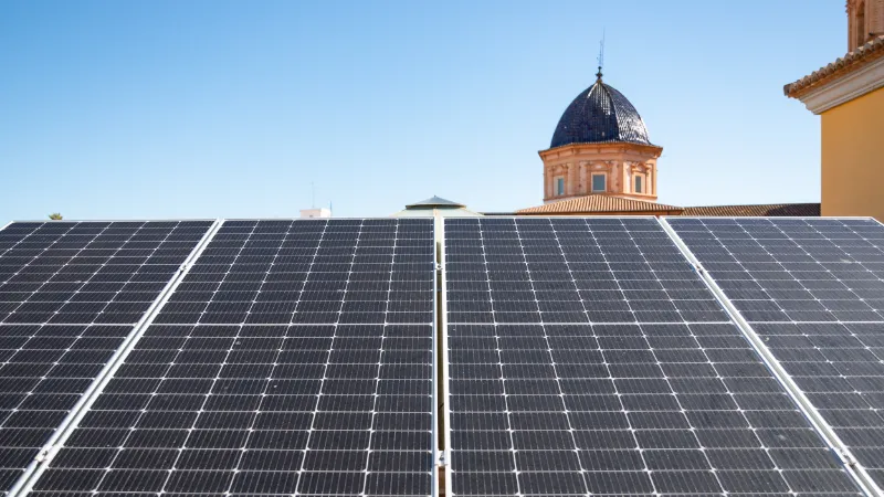 Instalación de paneles solares en una casa del pueblo de Foios, al fondo la parte superior de una iglesia