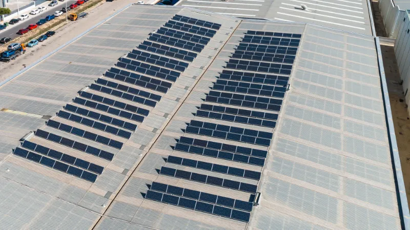 Vista aérea instalación placas solares sobre techo nave industrial en Paterna